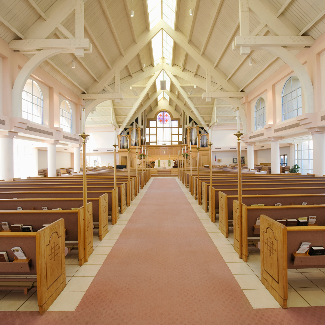 inside a religious establishment during the day time showing the clean area of the carpet and pews